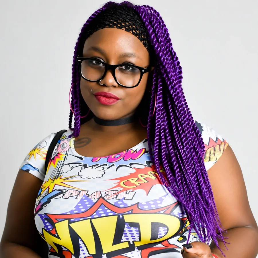 Jasmine Jazz Coleson, REALTOR®, in her signature glasses and vivid style.